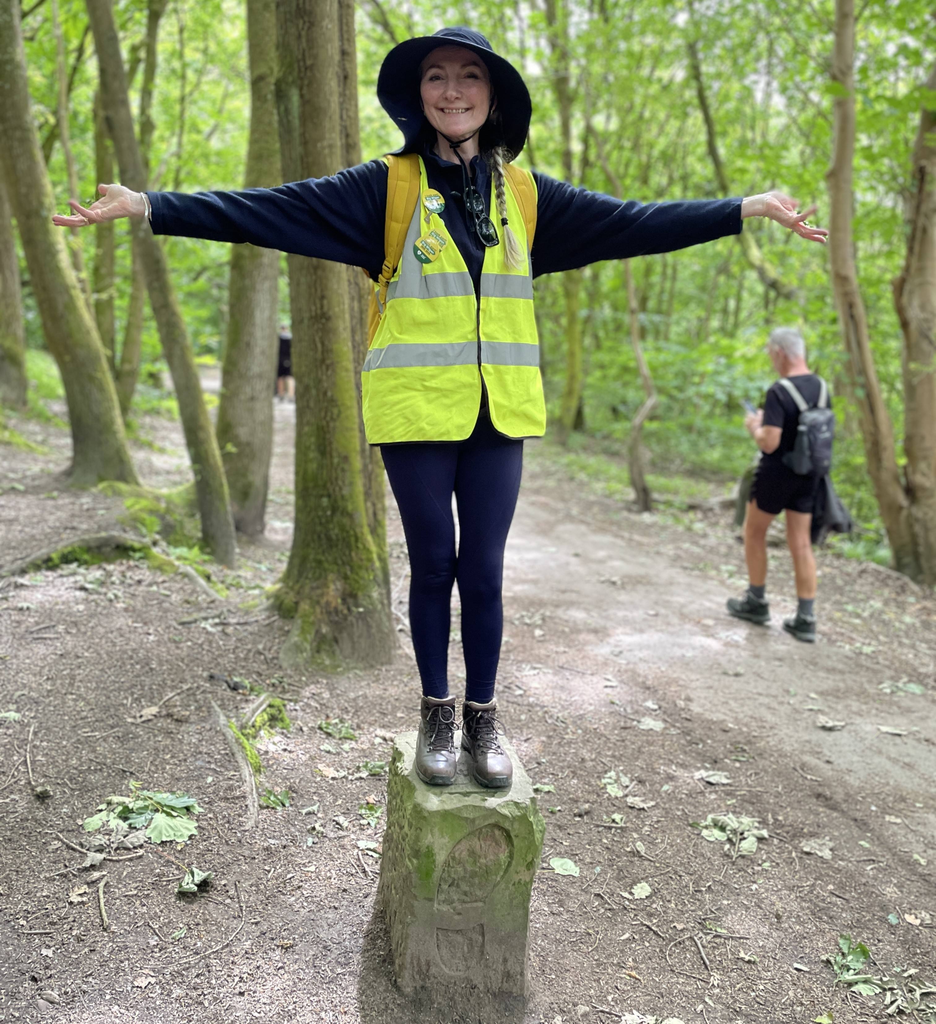 Bev Baldwin standing on a Wigan Way waymarker